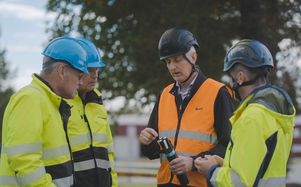 Three people in workwear discussing the pilot project in Norsjö, Sweden.