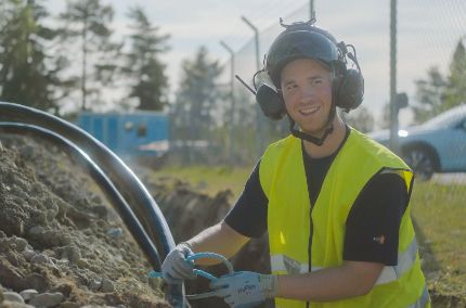 Distributionselektriker arbetar med kabelförläggning vid en nätstation i Skellefteå Krafts pilotprojekt.